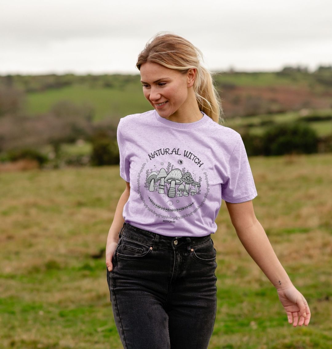 light purple organic t-shirt on a blonde haired model that says natural witch with mushrooms, moons and stars, designed by MooksGoo