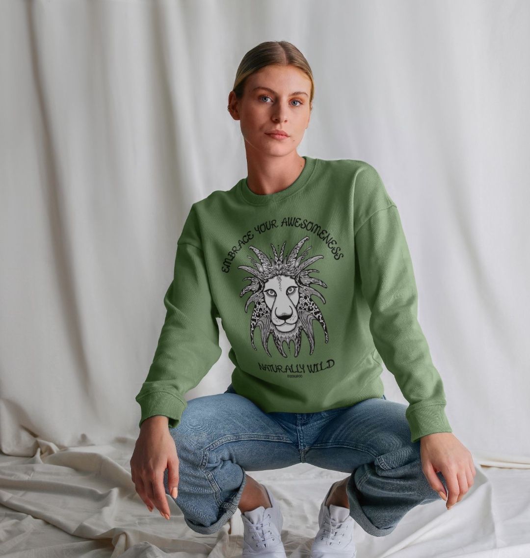 Model with brown hair wearing a sage green organic cotton oversized sweatshirt with embrace your awesomeness naturally wild fun typography, and an illustrated wild lion, designed by MooksGoo
