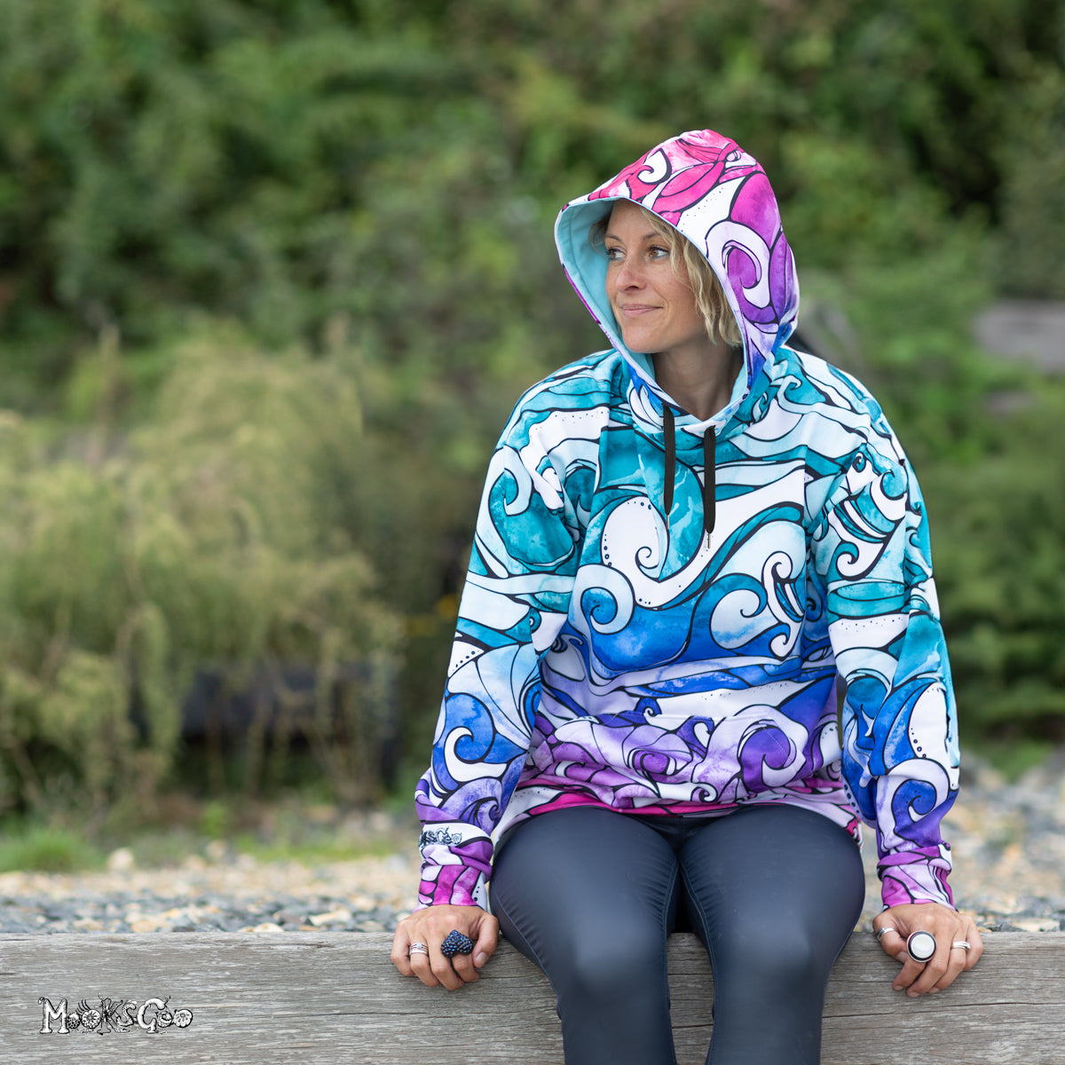 Model Michelle Lott wearing a size L unisex recycled rainbow wave hoodie, illustrated and designed by MooksGoo. Phot taken by Julian Winslow at Shanklin seafront on the Isle of Wight.