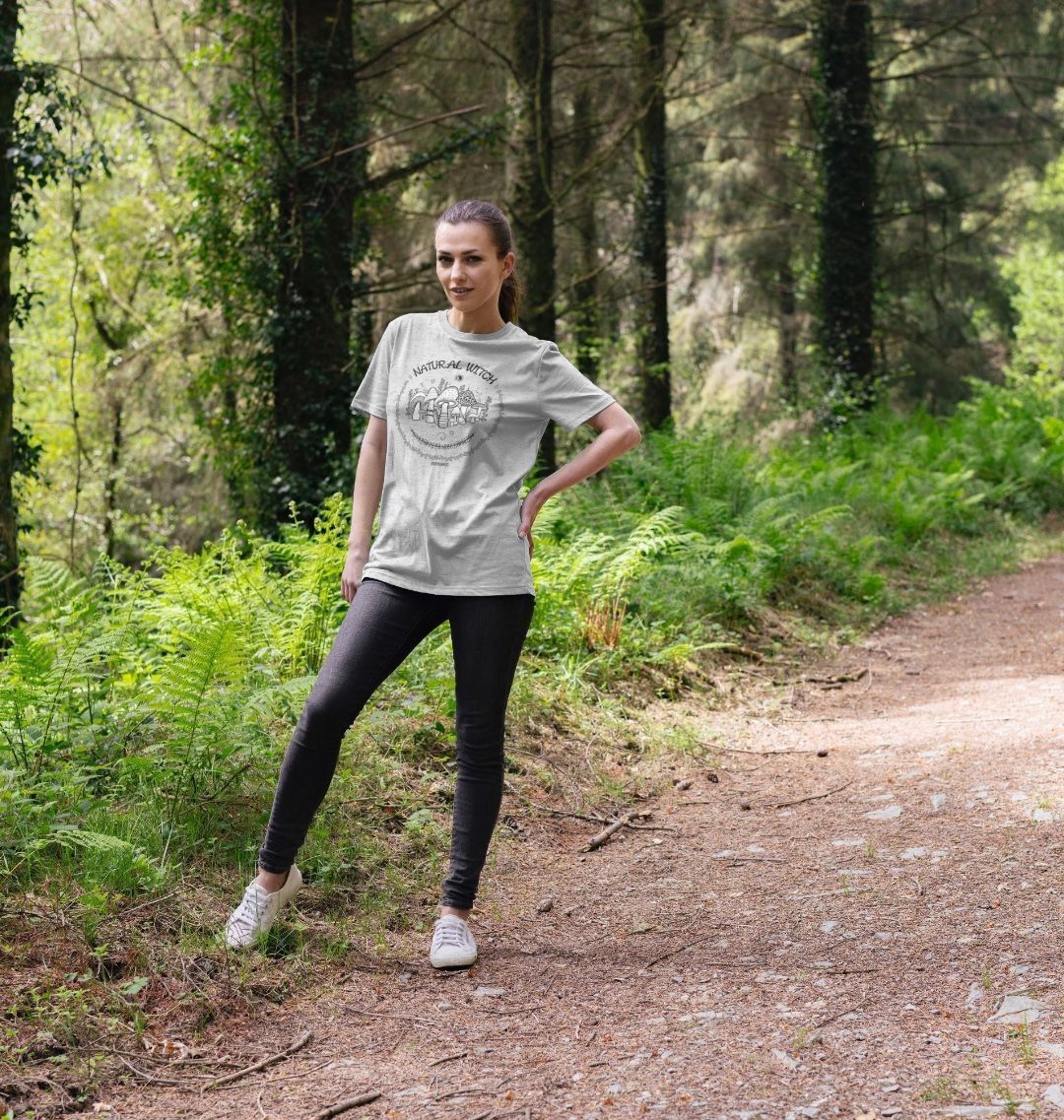 grey organic t-shirt on a dark haired model in the forest woods, that says natural witch with mushrooms, moons and stars, designed by MooksGoo