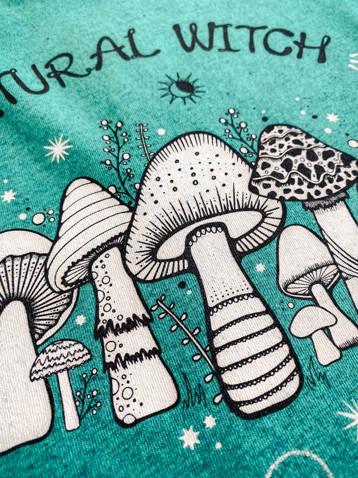 natural witch illustration printed on an organic cotton t-shirt, close up for texture and quality, designed by MooksGoo