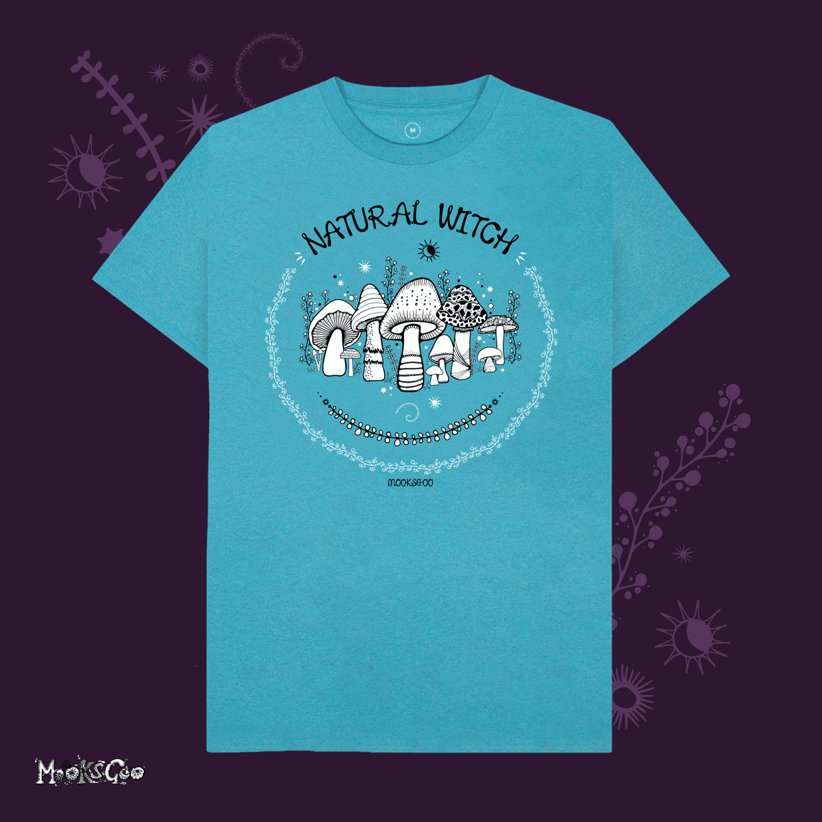 ocean blue organic cotton recycled t-shirt with script typography fonts that says natural witch, with black and white illustrations of mushrooms, toadstools, leaves, sun and moon and stars, designed by MooksGoo