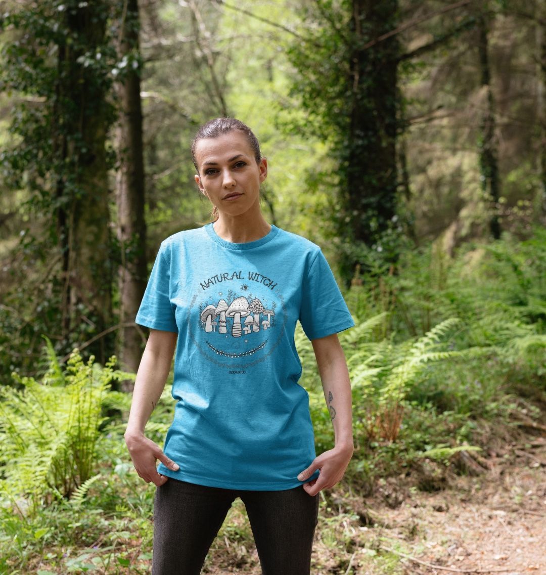 model wearing ocean blue natural organic t-shirt which says natural witch with mushrooms, sun and moon, designed by MooksGoo