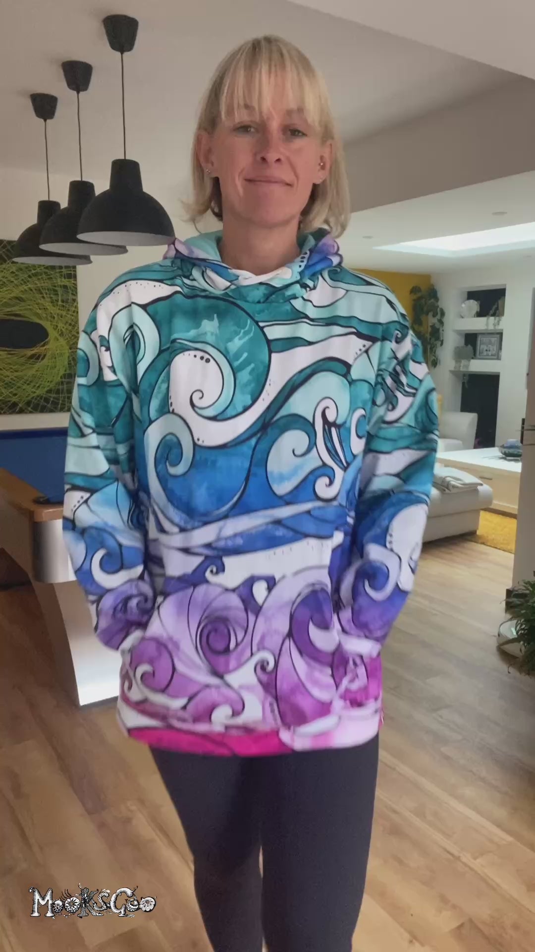 A woman wearing a colourful rainbow hoodie with illustrated waves, walking in a modern sitting room, designed by MooksGoo
