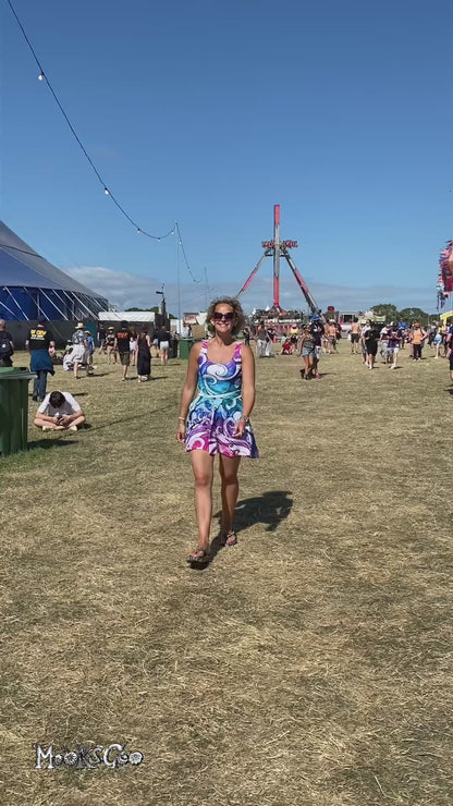 A woman at the Isle of Wight Festival, dancing in a rainbow wave flared dress, designed by MooksGoo