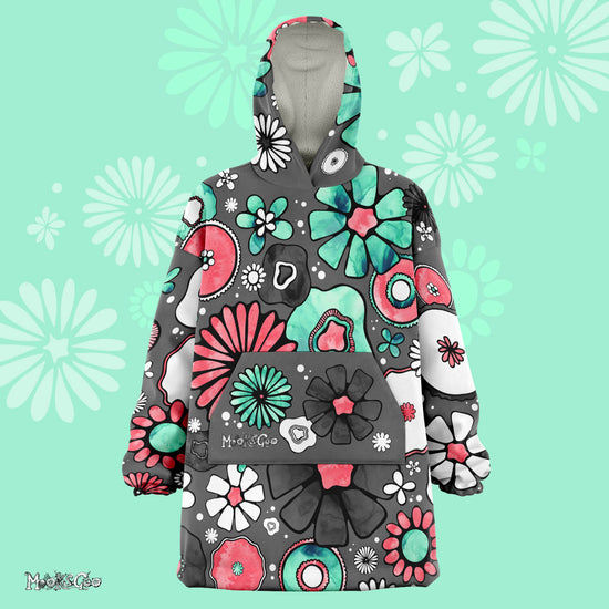 A lady dancing in a warm, thick Flower Power Snug Blanket Hoodie with illustrated flowers, designed by MooksGoo