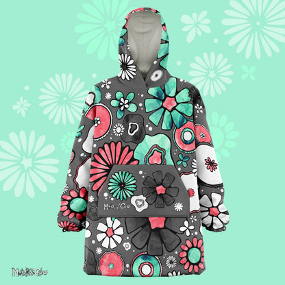 A lady dancing in a warm, thick Flower Power Snug Blanket Hoodie with illustrated flowers, designed by MooksGoo