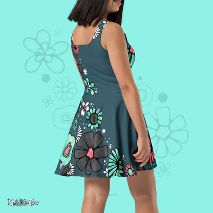 Side and back view of a model wearing a designer flower power dress, with the colours turquoise, coral pink, black and white, with a teal background. Illustrated dress design by MooksGoo