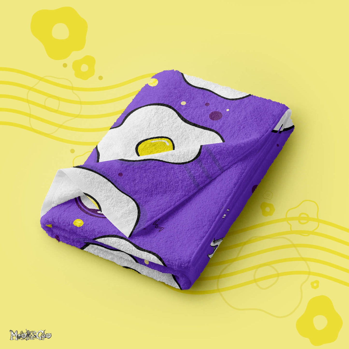 Getting Fried beach or bathroom towel with illustrated fried eggs, folded, designed by MooksGoo
